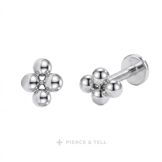 Two small metallic stud earrings on a white background: one gold-tone cluster of three rounded beads and one silver-tone cluster of three rounded beads with a barbell backing. The brand name PIERCE & TELL appears below.