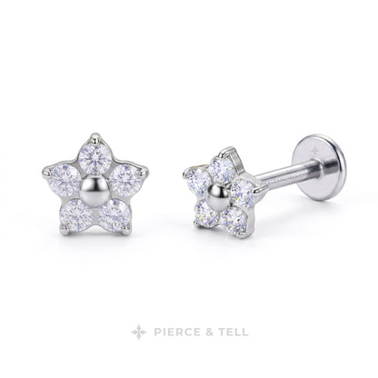 A pair of silver flower-shaped stud earrings with clear round-cut gemstones, shown on a clean white background. One earring is facing forward, and the other is angled to show the post and flat back.