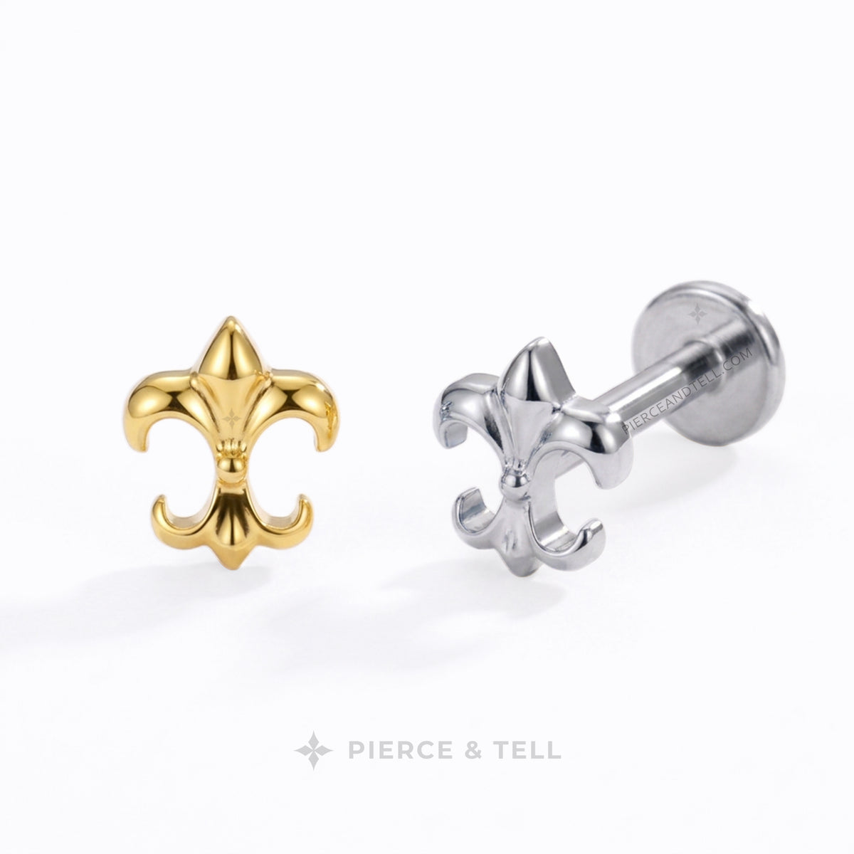 Two fleur-de-lis body jewelry studs by Pierce & Tell, one in polished yellow gold and the other in polished silver, displayed on a clean white background.