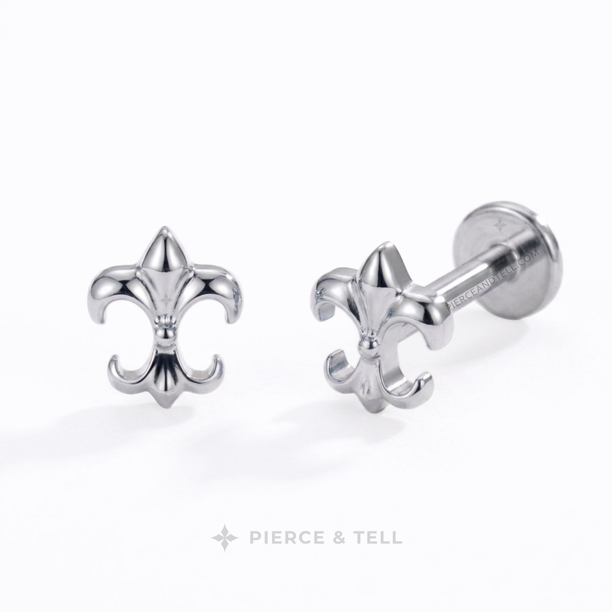 A pair of silver French fleur-de-lis barbell stud earrings by Pierce & Tell, shown on a clean white background with one earring facing forward and the other angled to show the post and flatback end.