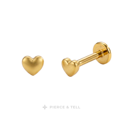 Gold heart-shaped labret stud earrings shown from front and side angles on a white background, with the PIERCE & TELL logo at the bottom.