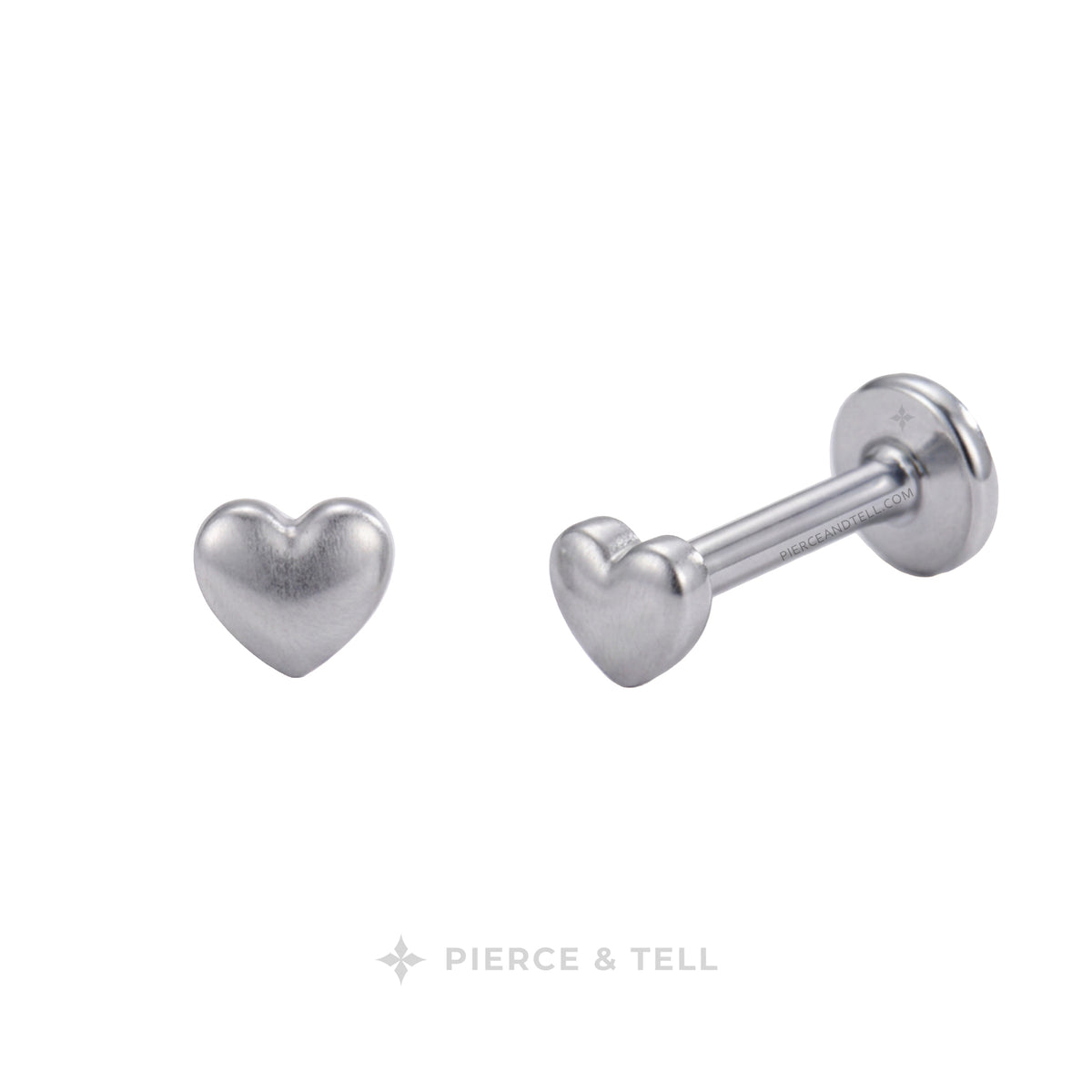 Silver heart-shaped labret stud earrings shown from front and side angles on a white background, with the PIERCE & TELL logo at the bottom.