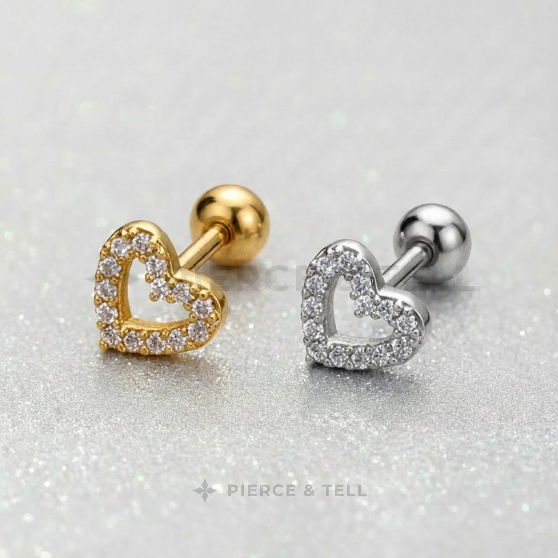 Gold and silver heart-shaped earrings on a glittery background with 'Pierce & Tell' branding.