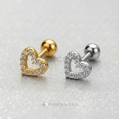 Gold and silver heart-shaped earrings on a glittery background with 'Pierce & Tell' branding.