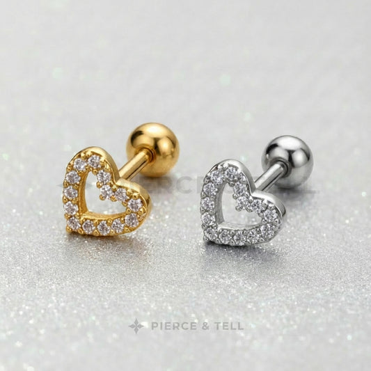 Gold and silver heart-shaped earrings on a glittery background with 'Pierce & Tell' branding.