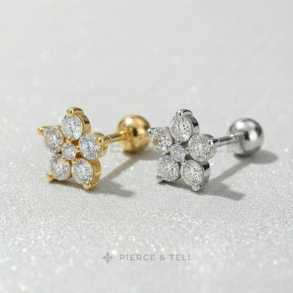 Gold and silver earrings with clear gemstones on a light gray background, branded 'Pierce & Tell'.