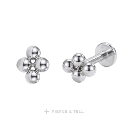 Two small metallic stud earrings on a white background: one gold-tone cluster of three rounded beads and one silver-tone cluster of three rounded beads with a barbell backing. The brand name PIERCE & TELL appears below.