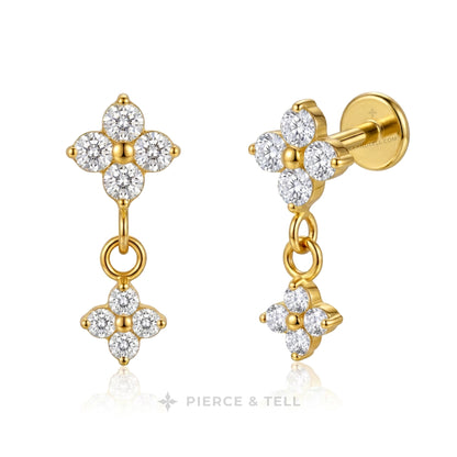A pair of gold drop earrings with diamond floral clusters, shown on a clean white background with a faint reflection. One earring is shown from the front, and the other shows the side profile with a post and backing.