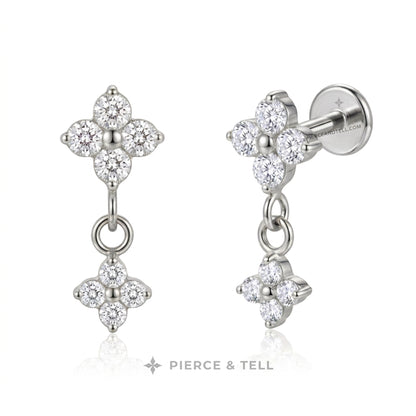 Two flower shape dangle stud earrings on a clean white background: one yellow gold curved row of clear stones and one silver flat row of clear stones, with the brand name PIERCE & TELL below.