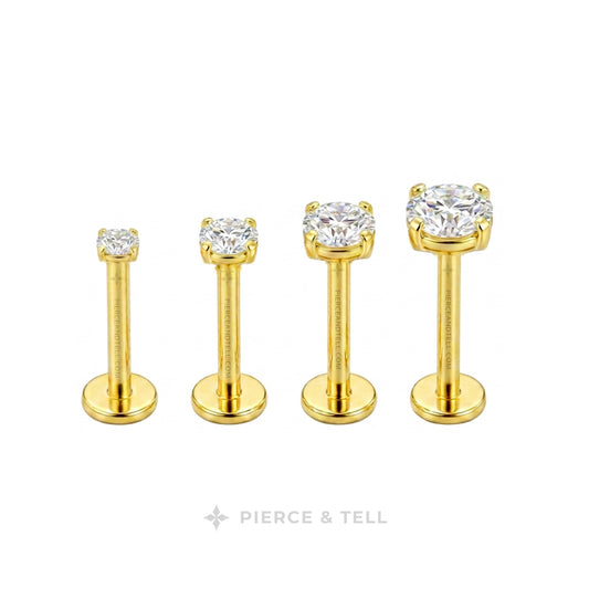 Four gold-colored labret ear piercings with clear round-cut gemstones, displayed in ascending size order on a white background with the brand name 'PIERCE & TELL' at the bottom.