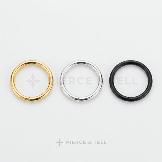 Three circular rings in gold, silver, and black on a white background with 'Pierce & Tell' branding.